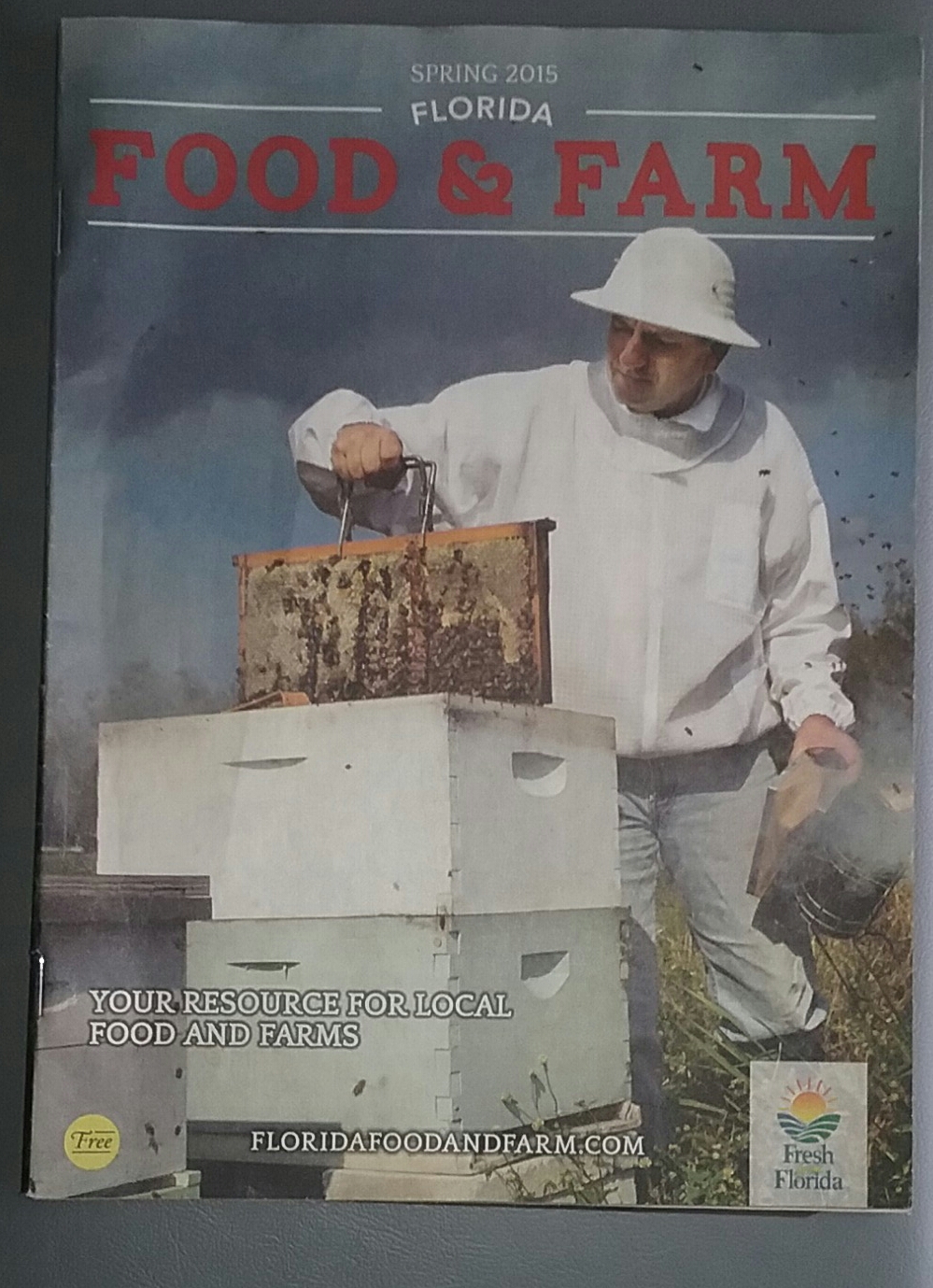 Food and farm magazene with Steve Byers pulling a bee frame out of a bee hive