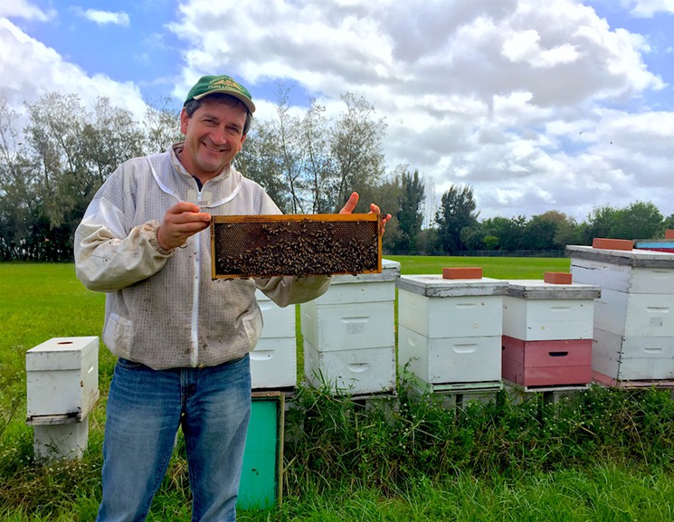 Steve Byers holds up a bee frame